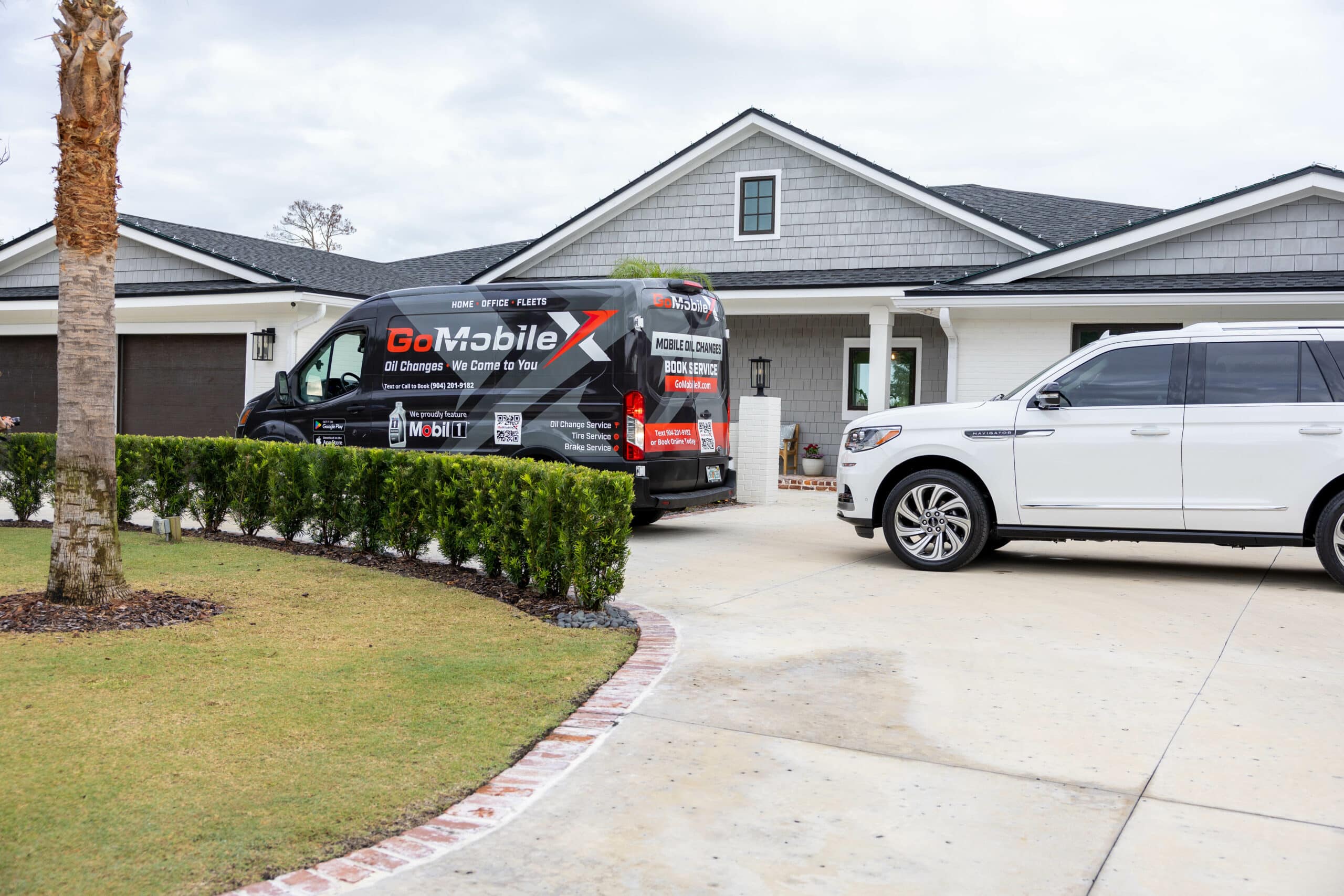 Mobile technician performing a full synthetic oil change at a customer driveway